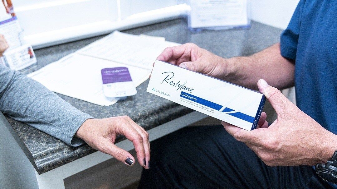Dr. Sattele shows a patient a box of Restylane dermal filler during a consultation at Rapid Weight Loss Centers in the Pee Dee and Grand Strand region of South Carolina.
