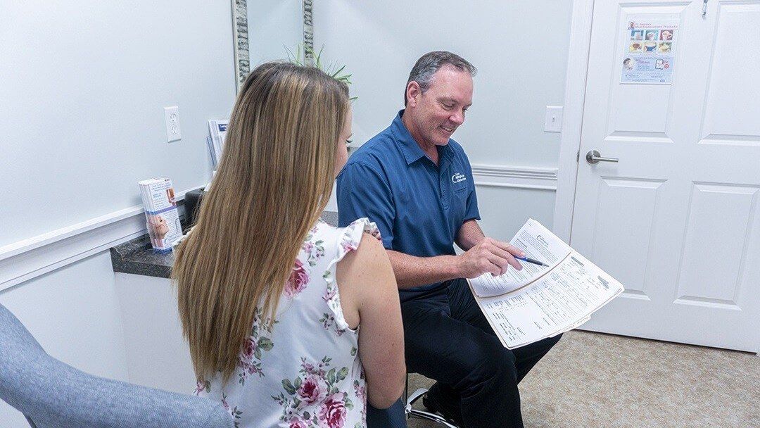 Dr. Kevin Sattele reviewing medical weight loss program details with a patient in an exam room at Rapid Weight Loss Centers in the Pee Dee and Grand Strand region of South Carolina.